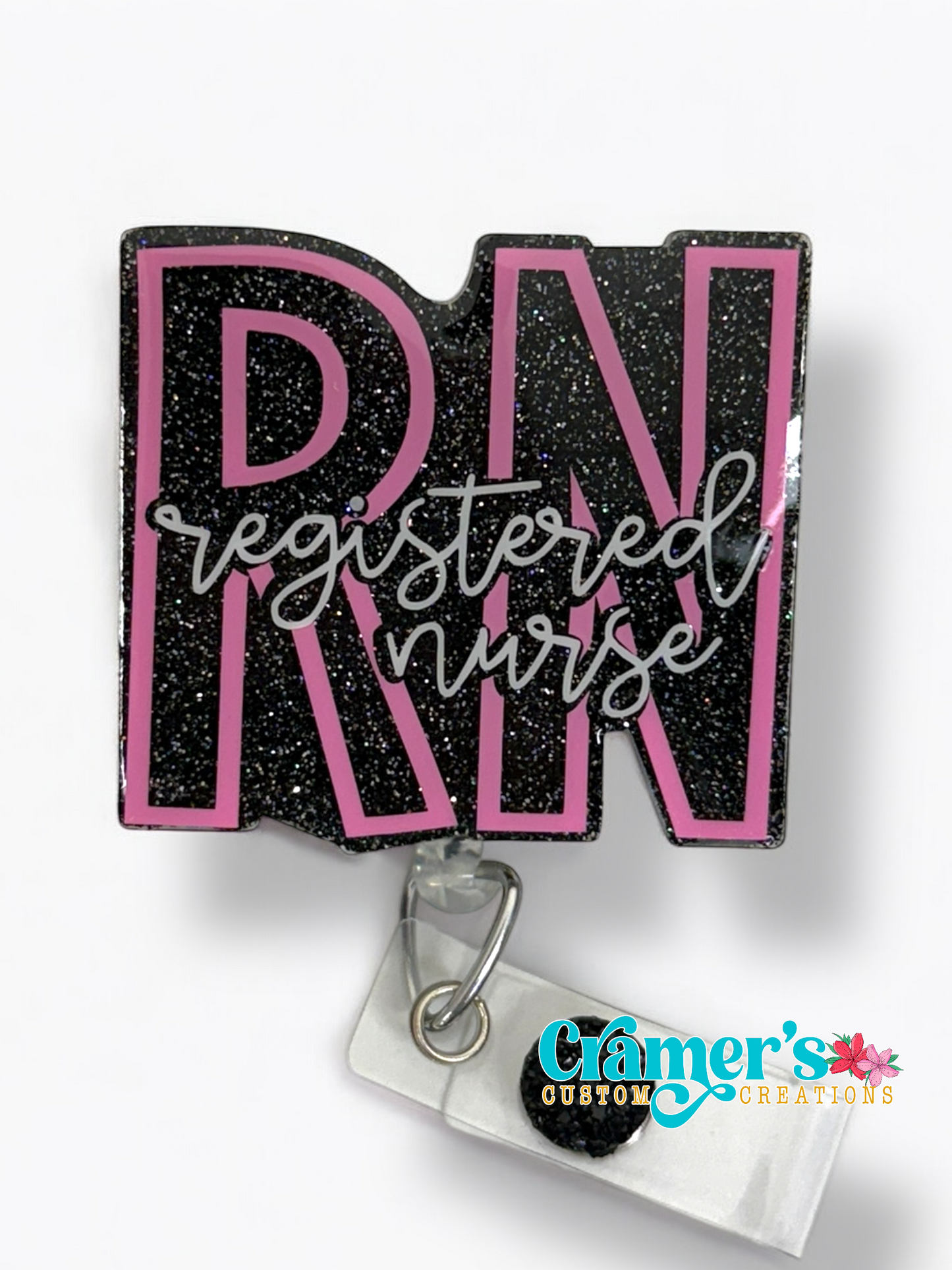badge reel showing a black glitter background with the initials in pink and registered nurse in white