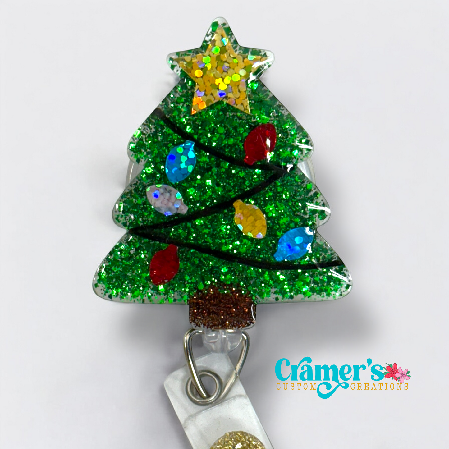 Glittery green christmas tree badge reel with colored bulbs and a gold star