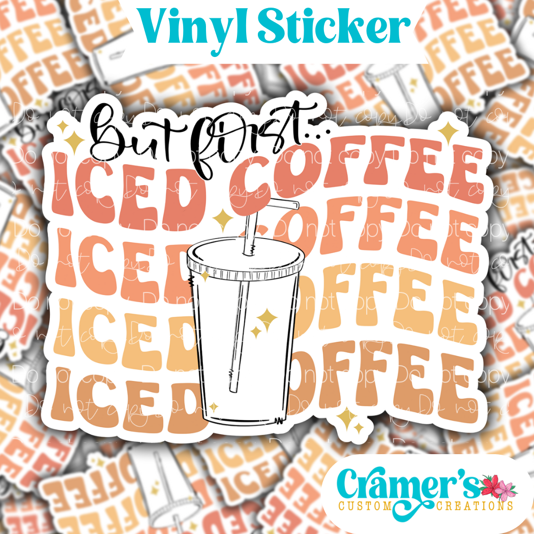A vinyl sticker with a design that includes a coffee cup and the text 'But First Iced Coffee' in stylized font, on a background pattern.