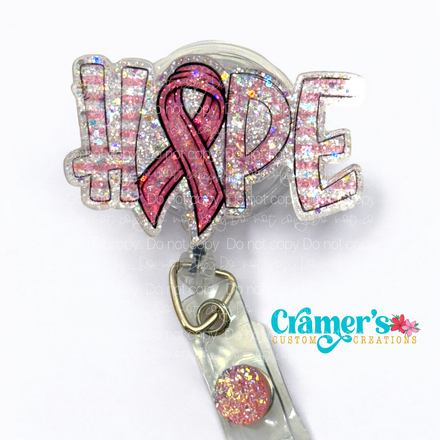 The word hope in pink and white with a ribbon for the O, all sparkling, on a badge reel
