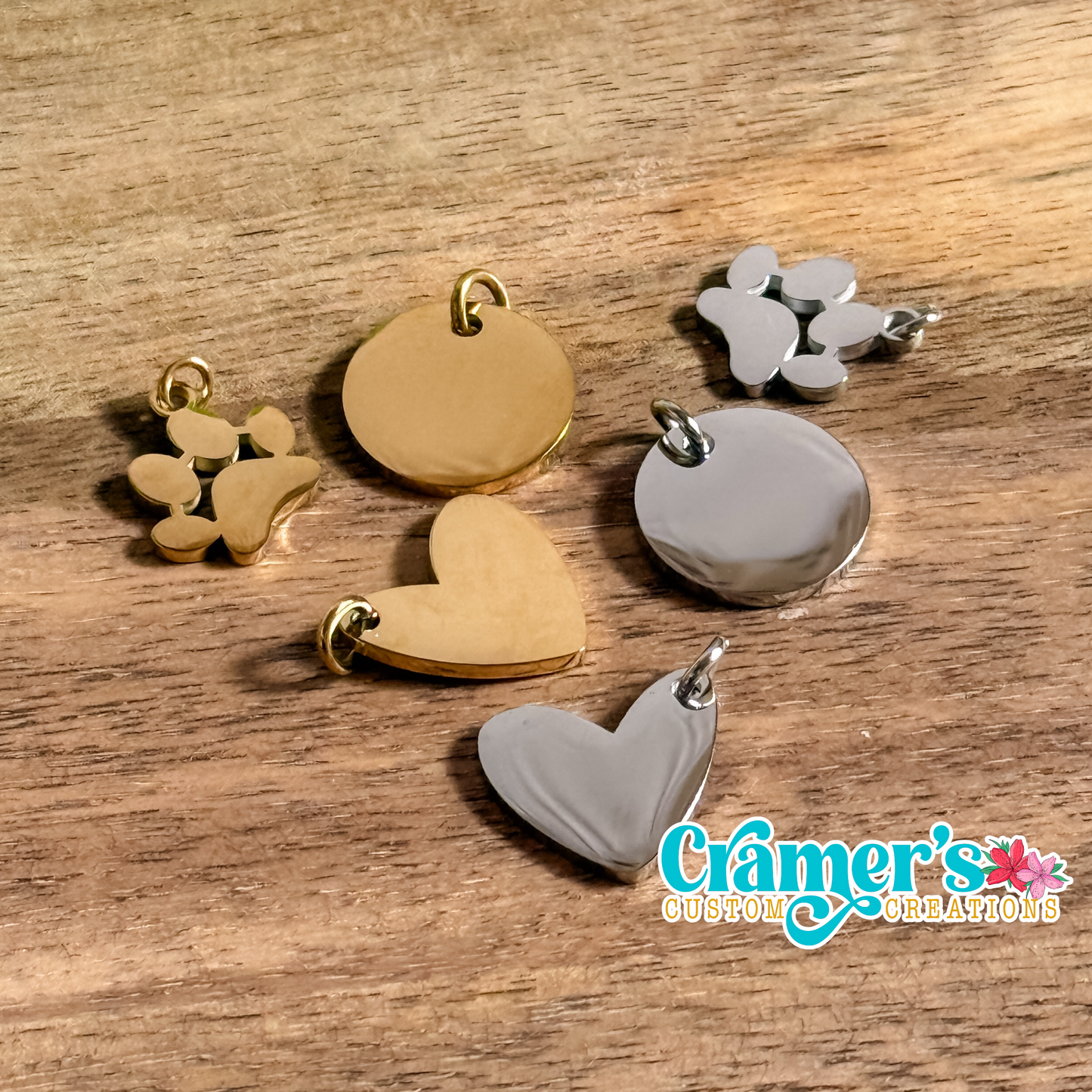 mulitiple charms in silver and gold on a wood backgrounf