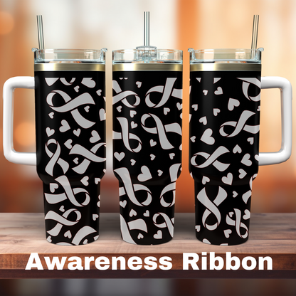 Three 40 oz tumblers with a black and white engraved design featuring awareness ribbons and hearts, positioned on a wooden surface with a blurred background.