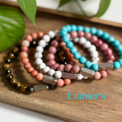 Set of beaded bracelets on a wooden surface with 'Gamer's' brand logo.
