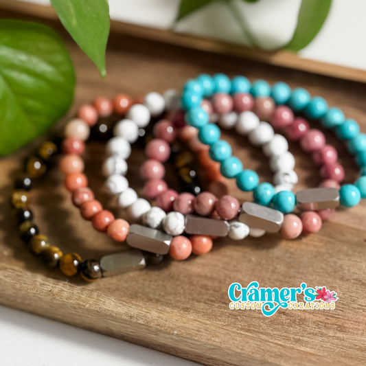 Set of beaded bracelets on a wooden surface with 'Gamer's' brand logo.