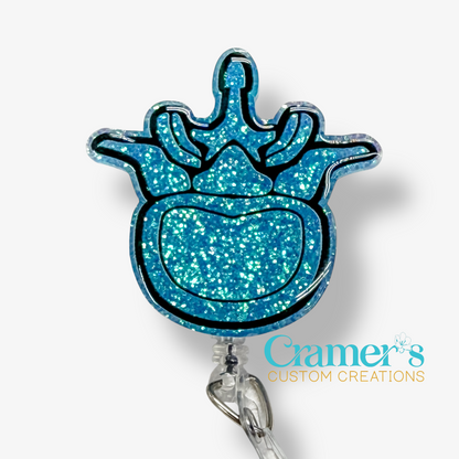 Blue glittery badge holder with a crown design on a white background, featuring the brand 'Cramer's Custom Creations'.
