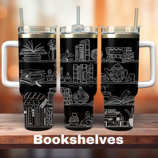 Two 40 oz stainless steel tumblers, one with a black powder-coated finish and bookshelf illustrations, and the other with a white finish. Both have straws and are placed on a wooden surface with a blurred background.
