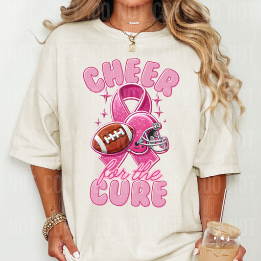 a shirt with a football, cancer ribbon, and helmet on it that says cheer for the cure