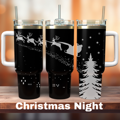 Two 40 oz black tumblers with Christmas-themed laser engraved designs featuring Santa's sleigh and reindeer, and a Christmas tree.