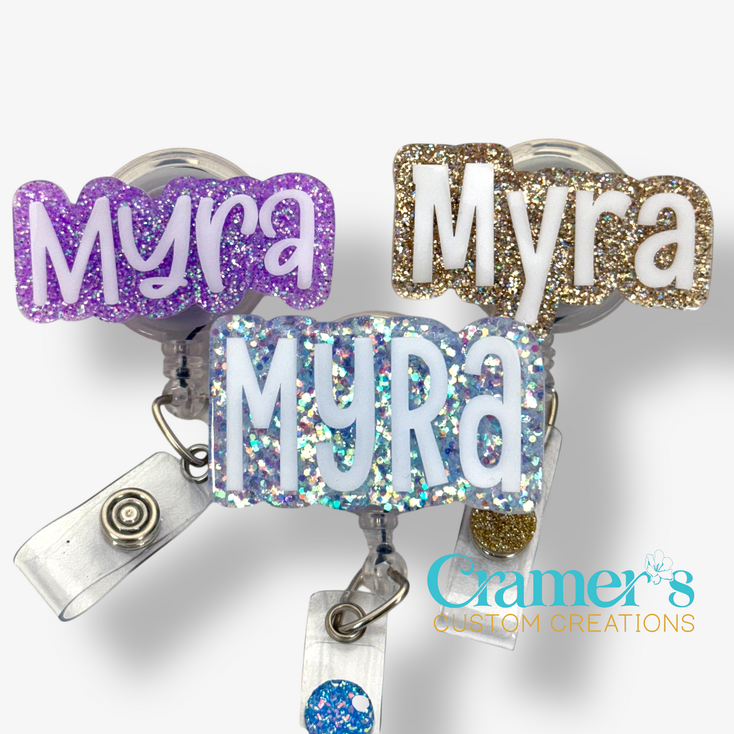 three badge reels with the name myra in 3 different fonts showing the difference in size