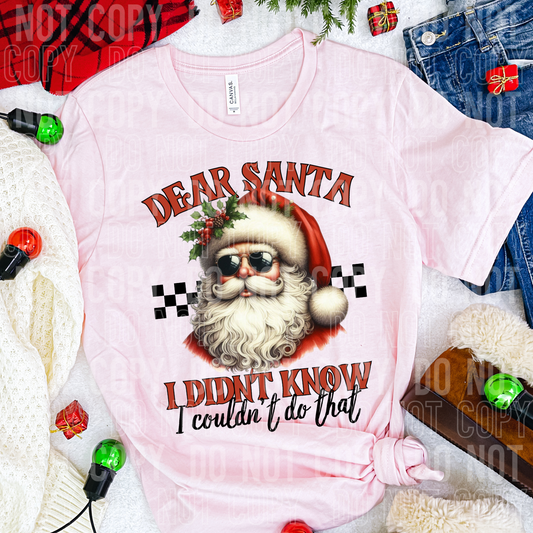 A shirt with dear santa I didn't know I couldn't do that surrounded by clothes and christmas decorations