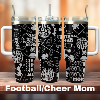 Three 40 oz black tumblers with white text and graphics related to football and cheerleading, each with a straw, displayed on a wooden surface with the text 'FOOTBALL/CHEER MOM' at the bottom.