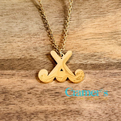 Gold necklace with a field hockey pendant on a wooden surface, featuring the Cramer's Custom Creations logo.
