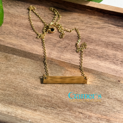 Gold necklace on a wooden surface with 'Cramer's Custom Creations' branding.