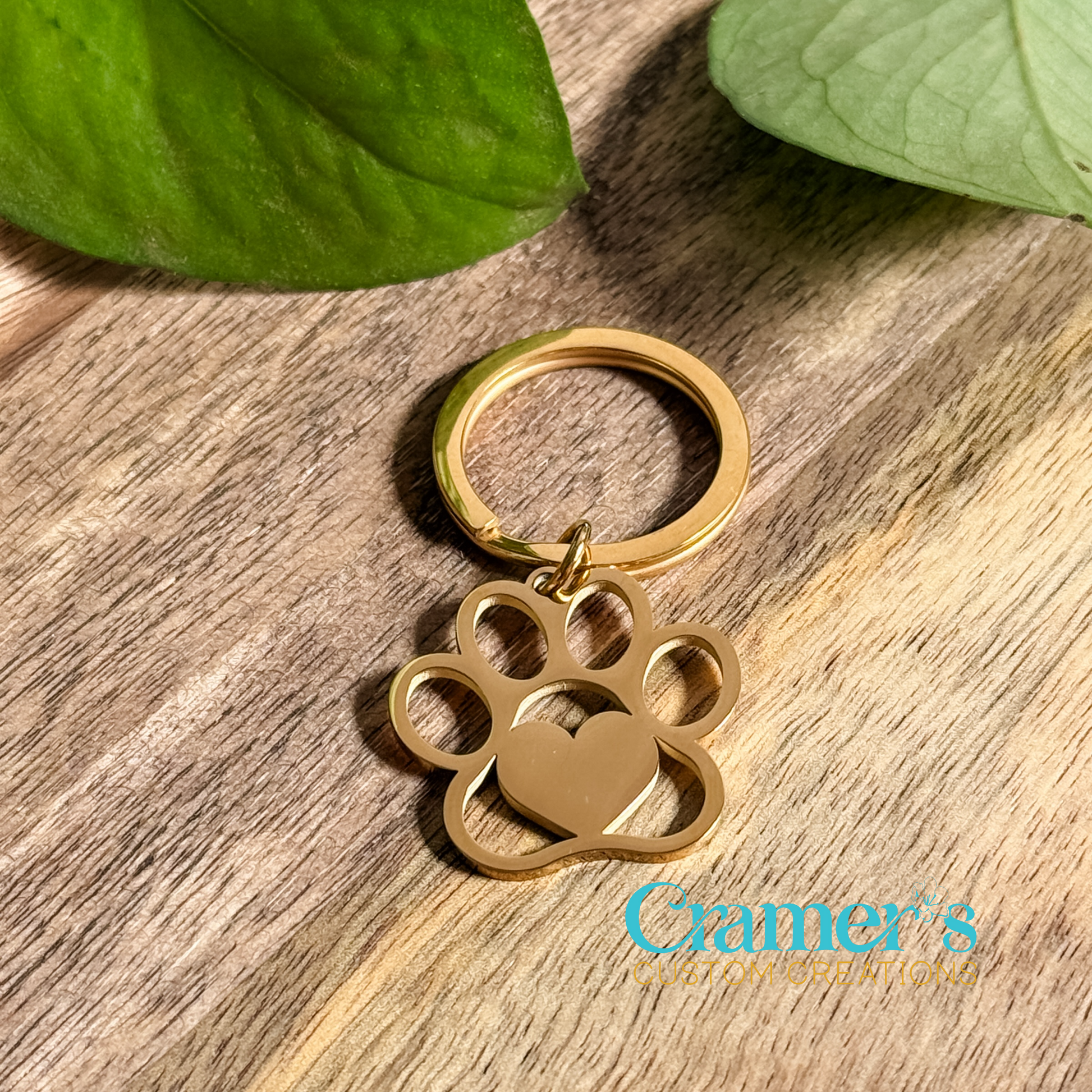 a gold paw print keychain on a wood background