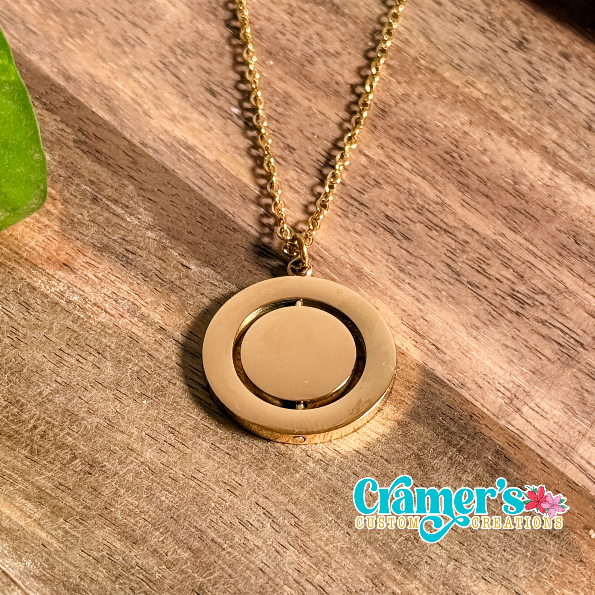 Gold rotating circle necklace on a wood background