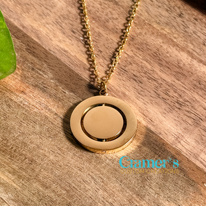 Gold rotating circle necklace on a wood background