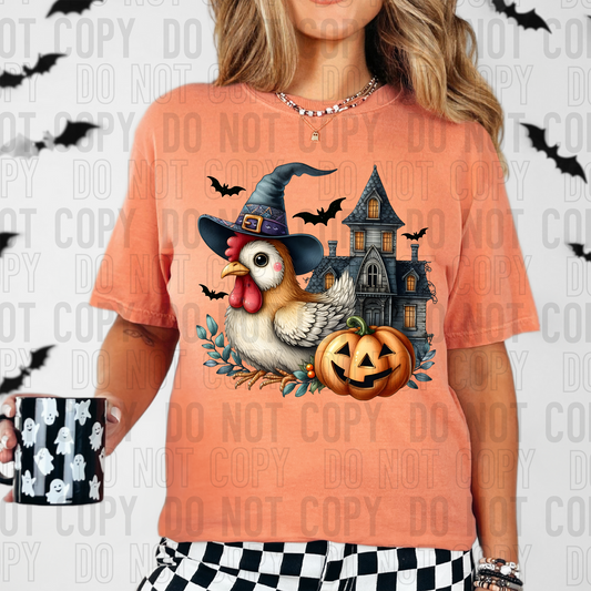 chicken with a witches hat sitting in front of a haunted house with a jackolantern