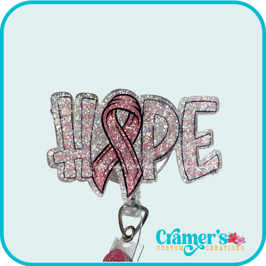 Glittery badge with the word hope in pink and white stripes with the 'o' being a cancer awareness ribbon