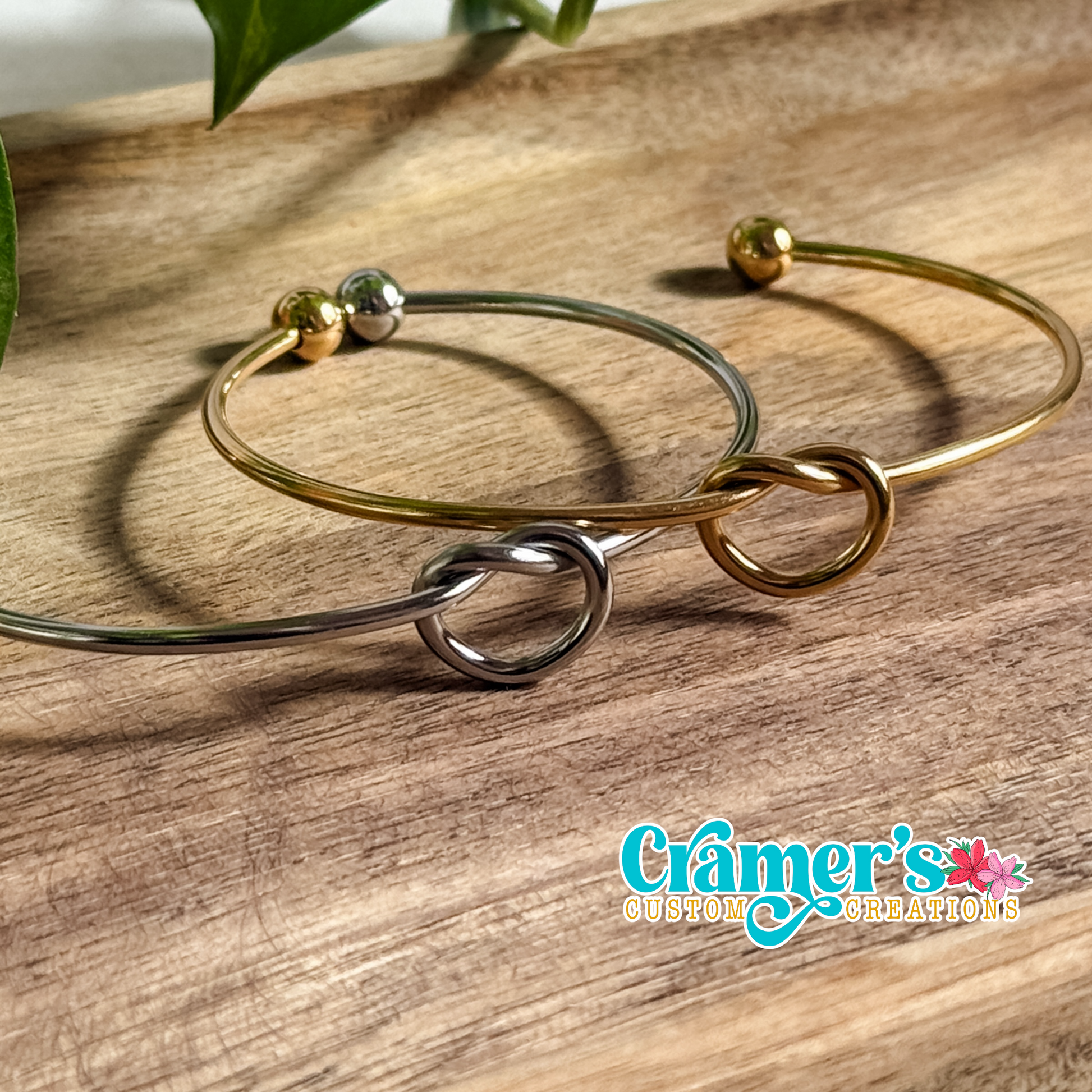 Silver and gold bracelets laying on a wood background
