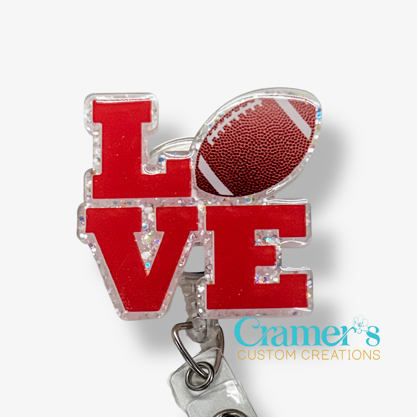 Red 'LOVE' charm with a football on a white background, featuring Cramer's Custom Creations logo.