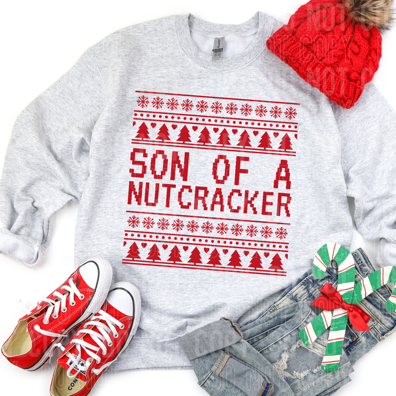 a sweatshirt with son of a nutcracker written in christmas sweater style with christmas style clothing and accessories around it.