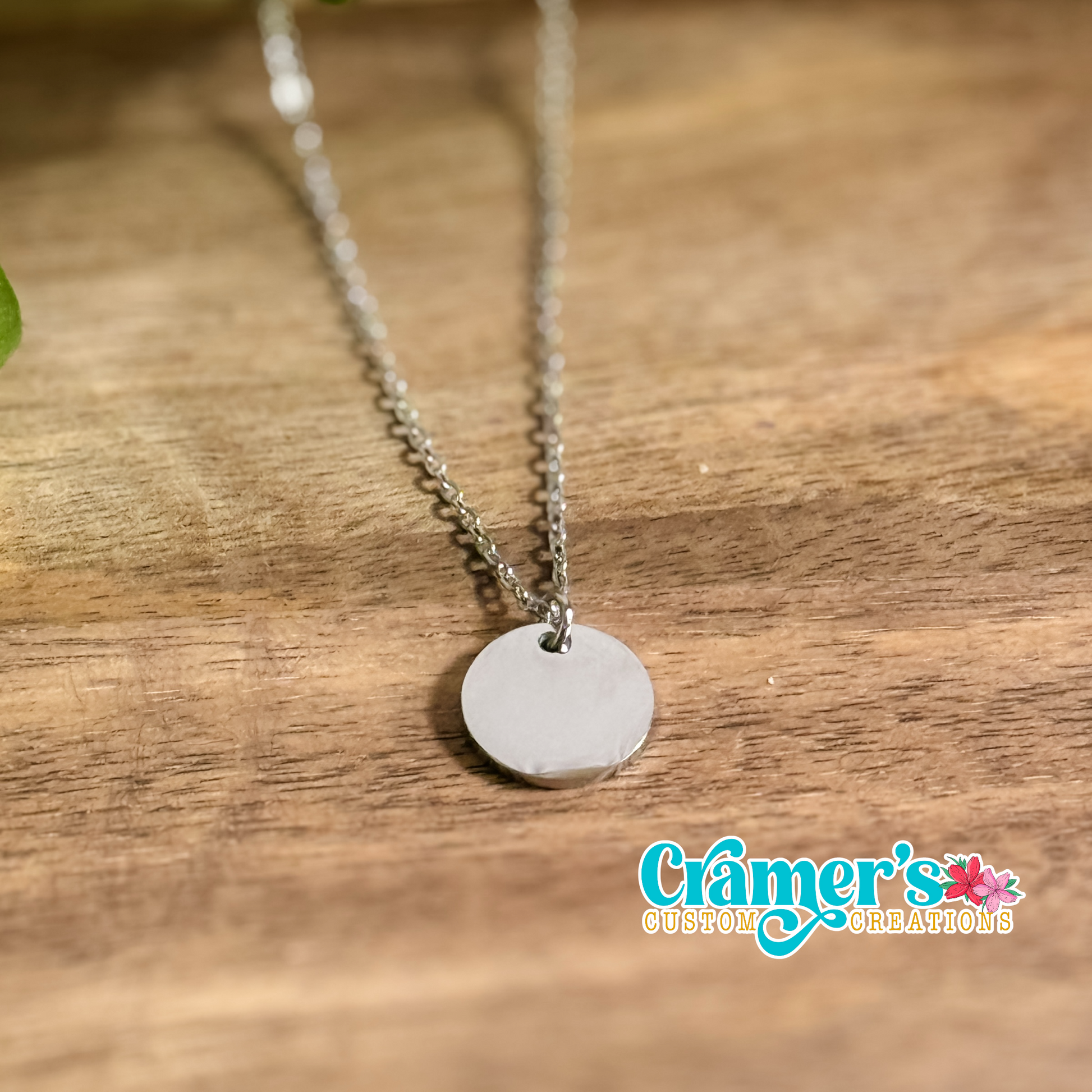 silver 15mm circle necklace on a wood background