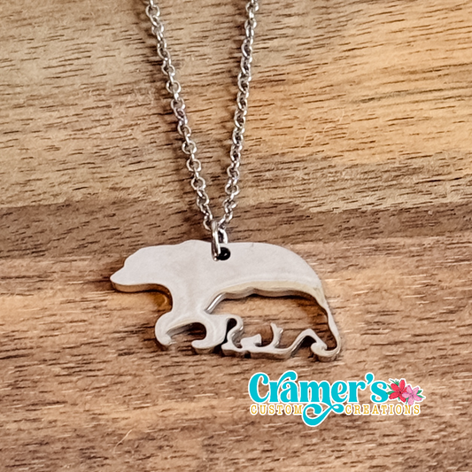 Silver necklace with a bear pendant on a wooden surface, featuring 'Gamer's Custom Creations' logo.