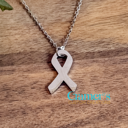 Silver ribbon pendant necklace on a wooden surface with 'Grifer's Custom Creations' branding.