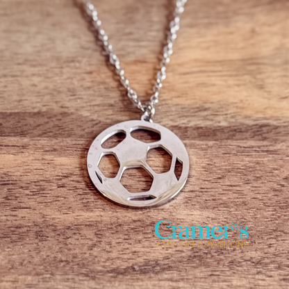 Silver soccer ball pendant necklace on a wooden surface with 'Cramer's Custom Creations' branding.