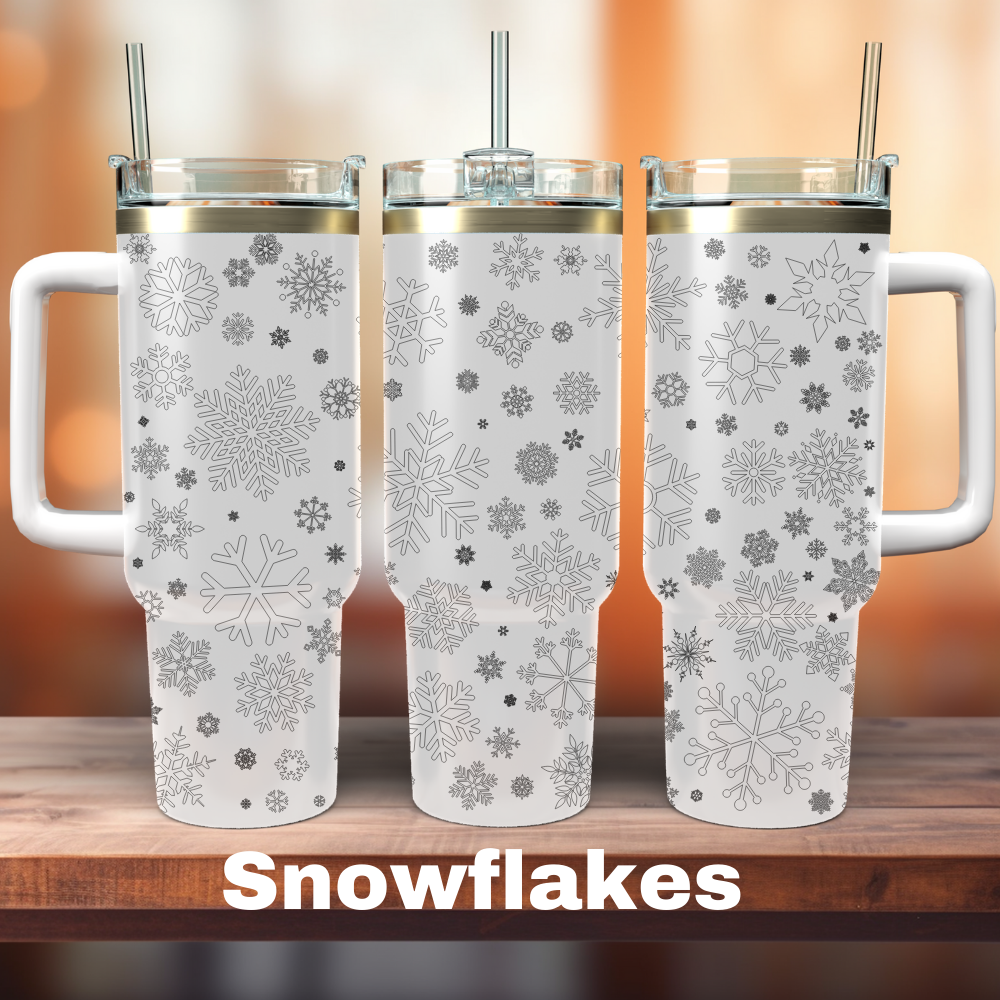 Three white 40 oz tumblers with a snowflake design and laser engraved details, displayed on a wooden surface.