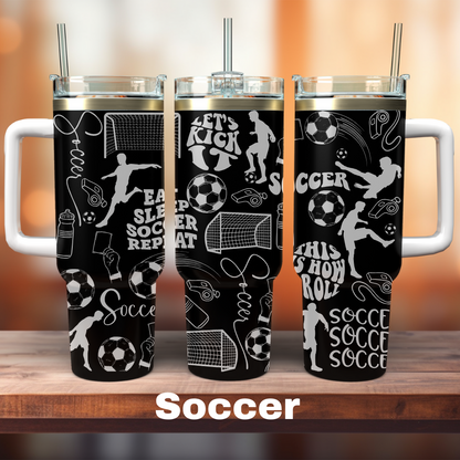 Three black 40 oz tumblers with white text and graphics related to soccer, placed on a wooden surface with a blurred background.