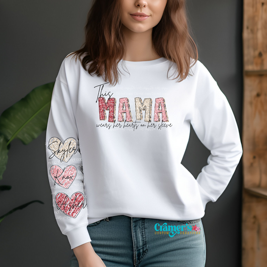 A woman wearing a white long-sleeve t-shirt with text and heart graphics on the sleeves.