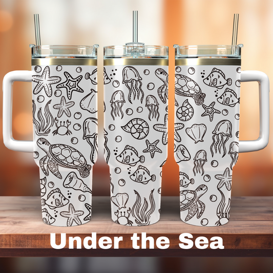 Three white 40 oz tumblers with laser engraved under the sea themed designs, including shells and sea life.