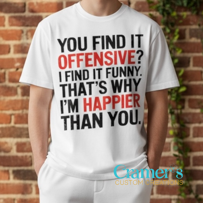 Person wearing a white t-shirt with a humorous message in front of a brick wall.