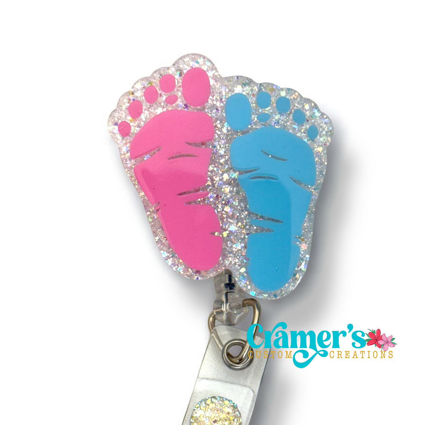 badge reel of two footprints one pink one blue with a white glitter backgound