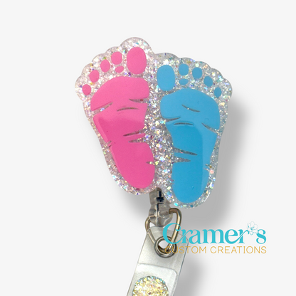 badge reel of two footprints one pink one blue with a white glitter backgound