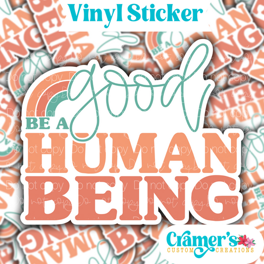 Sticker laying flat that says be a good human being on a background of the same sticker stacked up