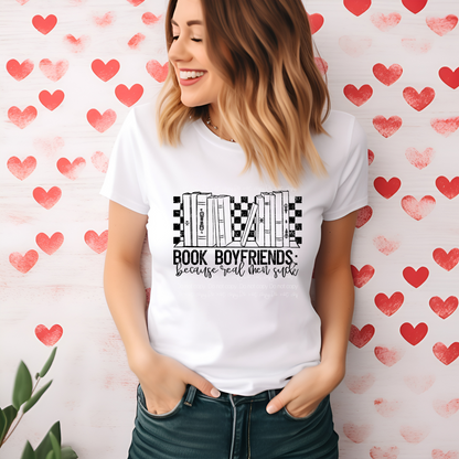 A person smiling and wearing a white t-shirt with a printed text that reads 'BOOK BOYFRIENDS because you're too cool to be just a friend' on the front, against a heart-patterned background.