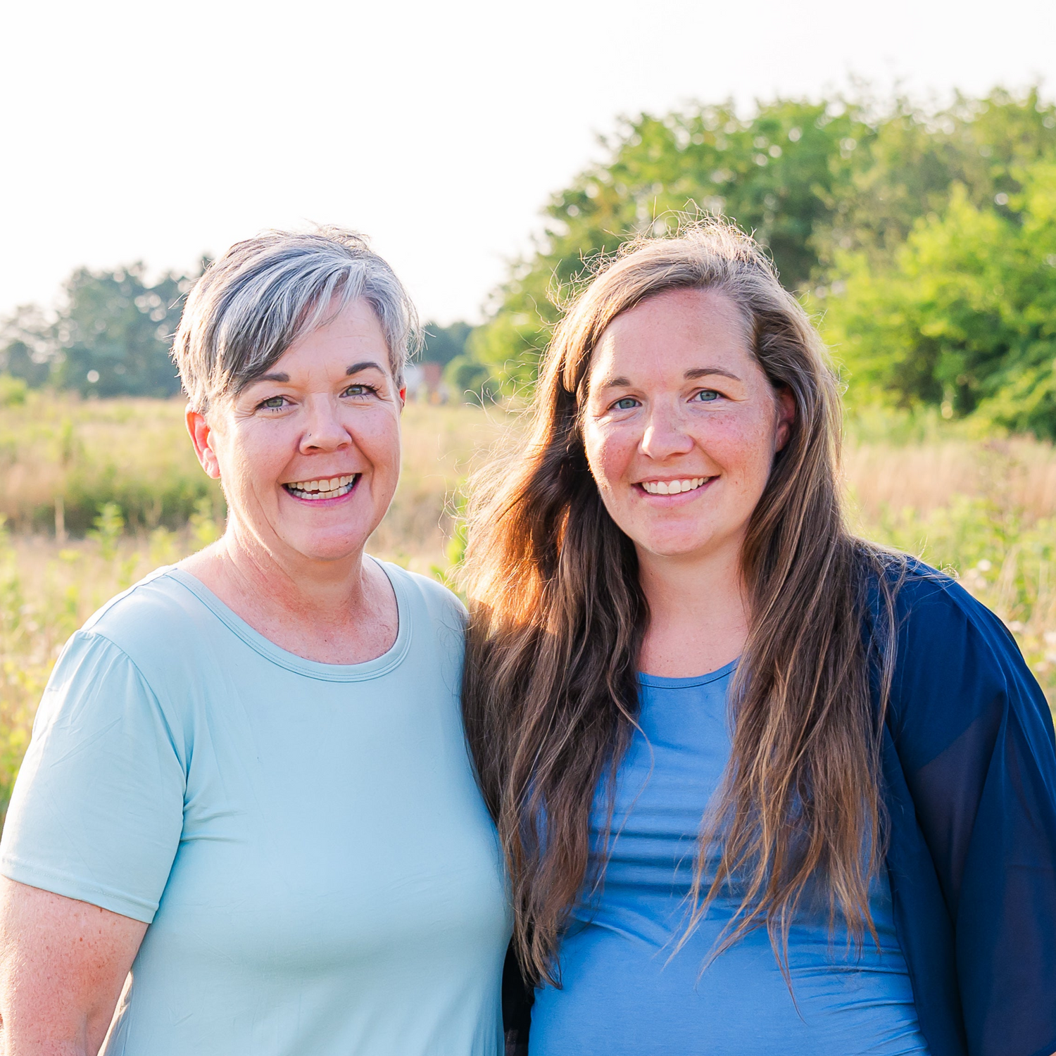 photo of two women in a field from the waste up