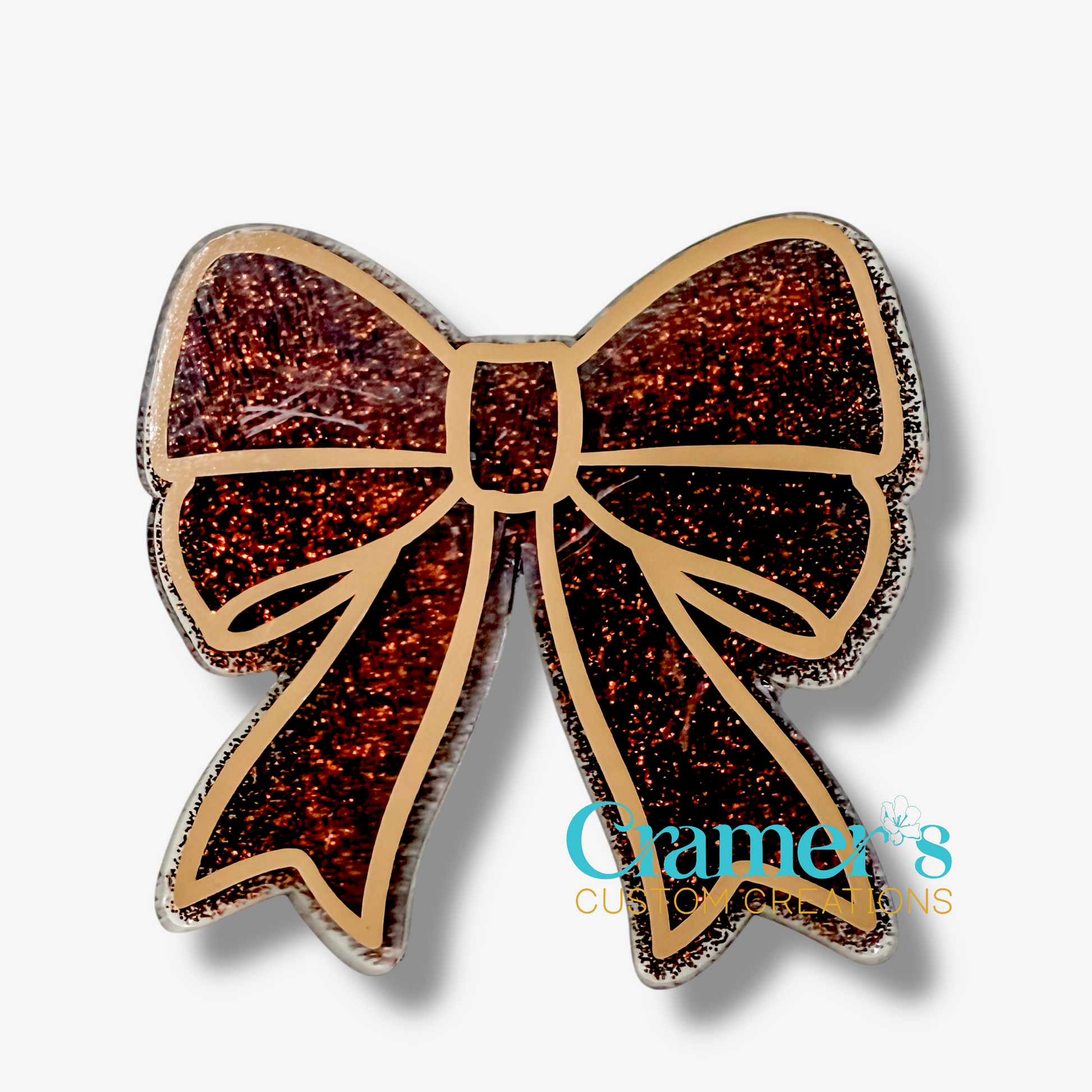 Brown Glittery bow-shaped object with 'Cramer's Custom Creations' logo on a white background