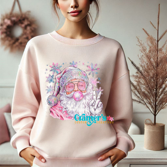 person wearing a light pink sweatshirt with an image of a bubble gum santa with a peace sign