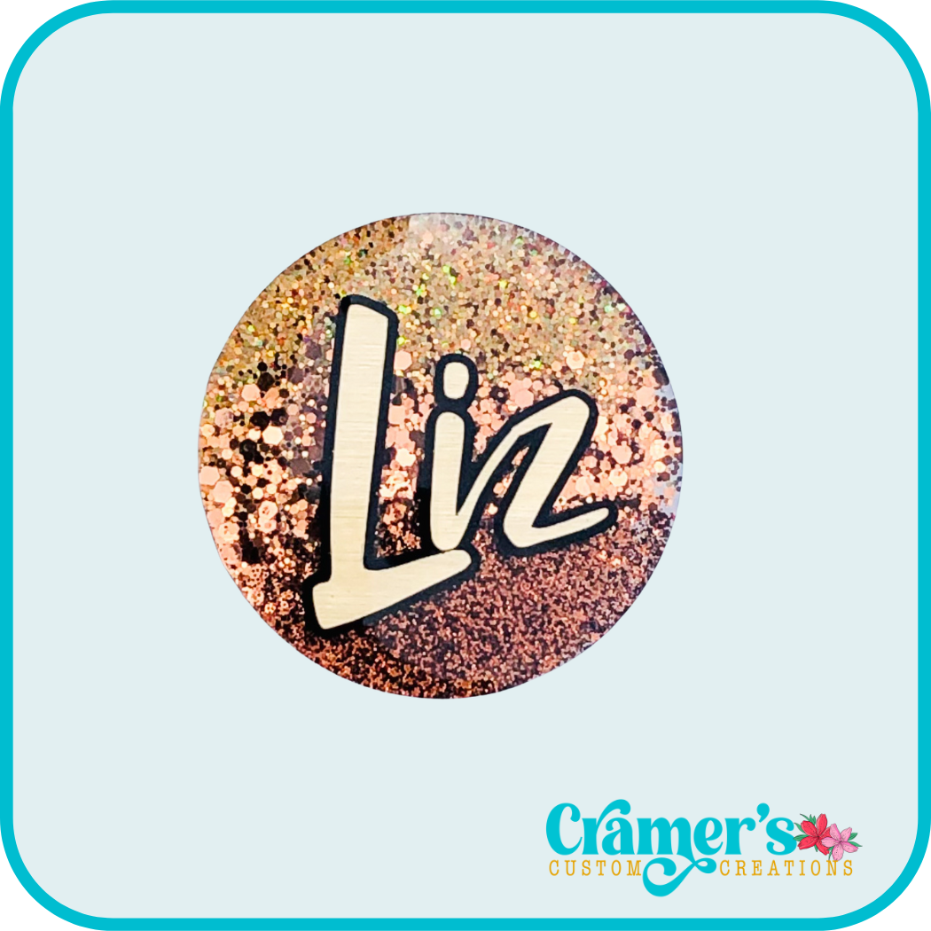 circle badge in shades of brown and copper with the name Liz in gold