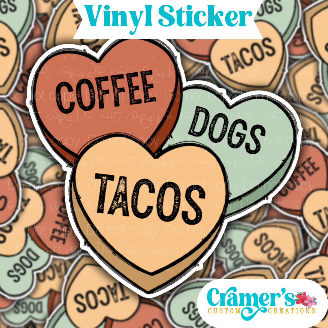 Sticker laying flat that says coffee dogs tacos in hearts on a background of the same sticker stacked up