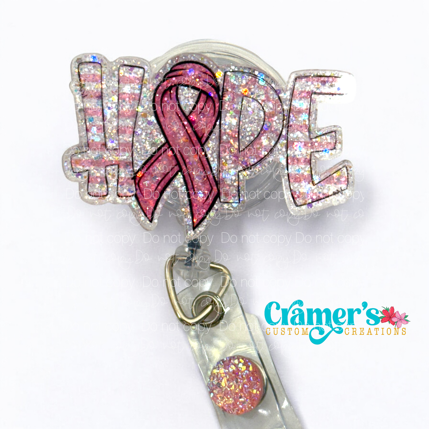 A badge reel showing the word hope with a ribbon as the letter O with a pink color and glitter back ground