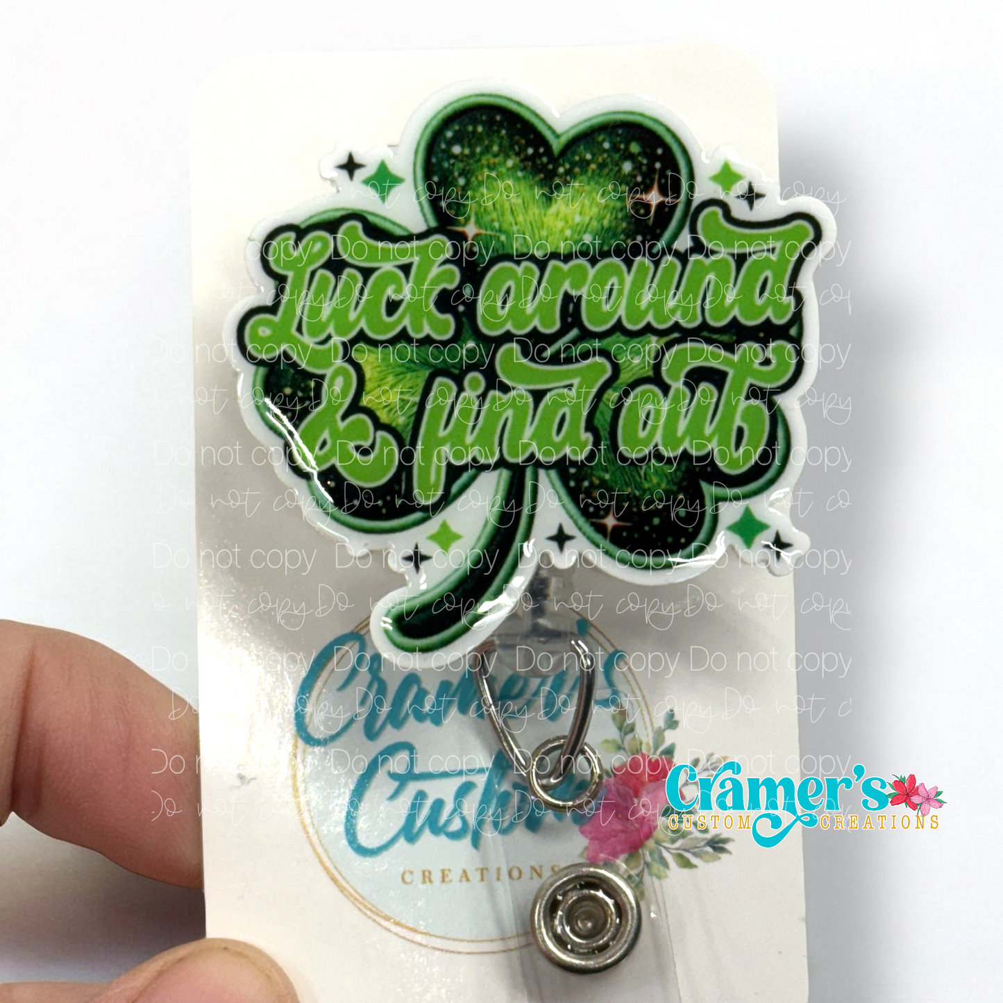 badge reel showing a non glitter option of a shamrock that says luck around and find out