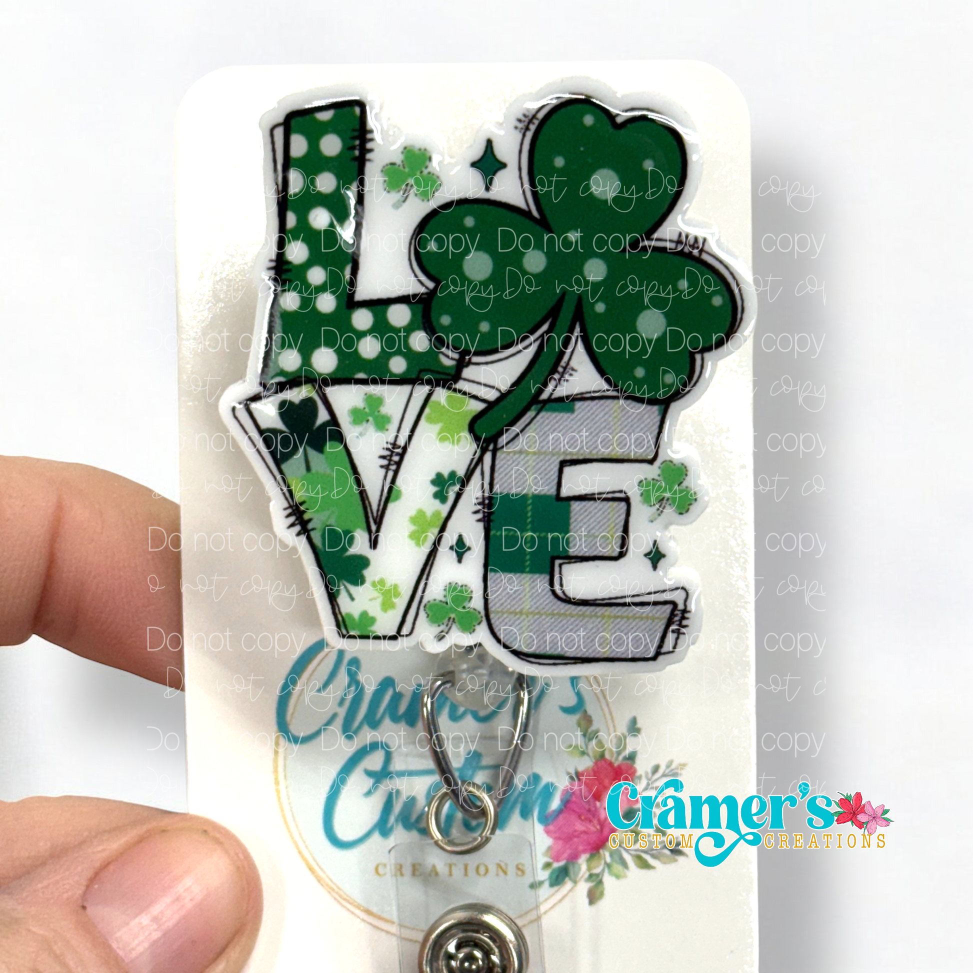 badge reel showing anon glitter option of a badge with the word love with a shamrock being the O