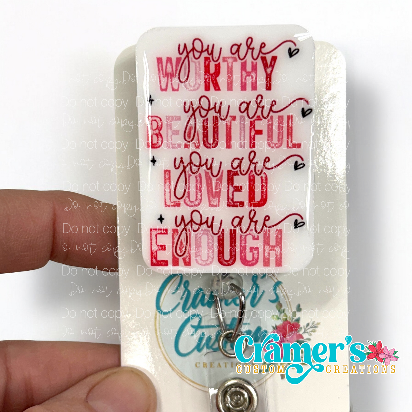 badge reel showing a non glitter option of a badge with the words you are worthy you are beautiful, you are loved, you are enough in pink and red text