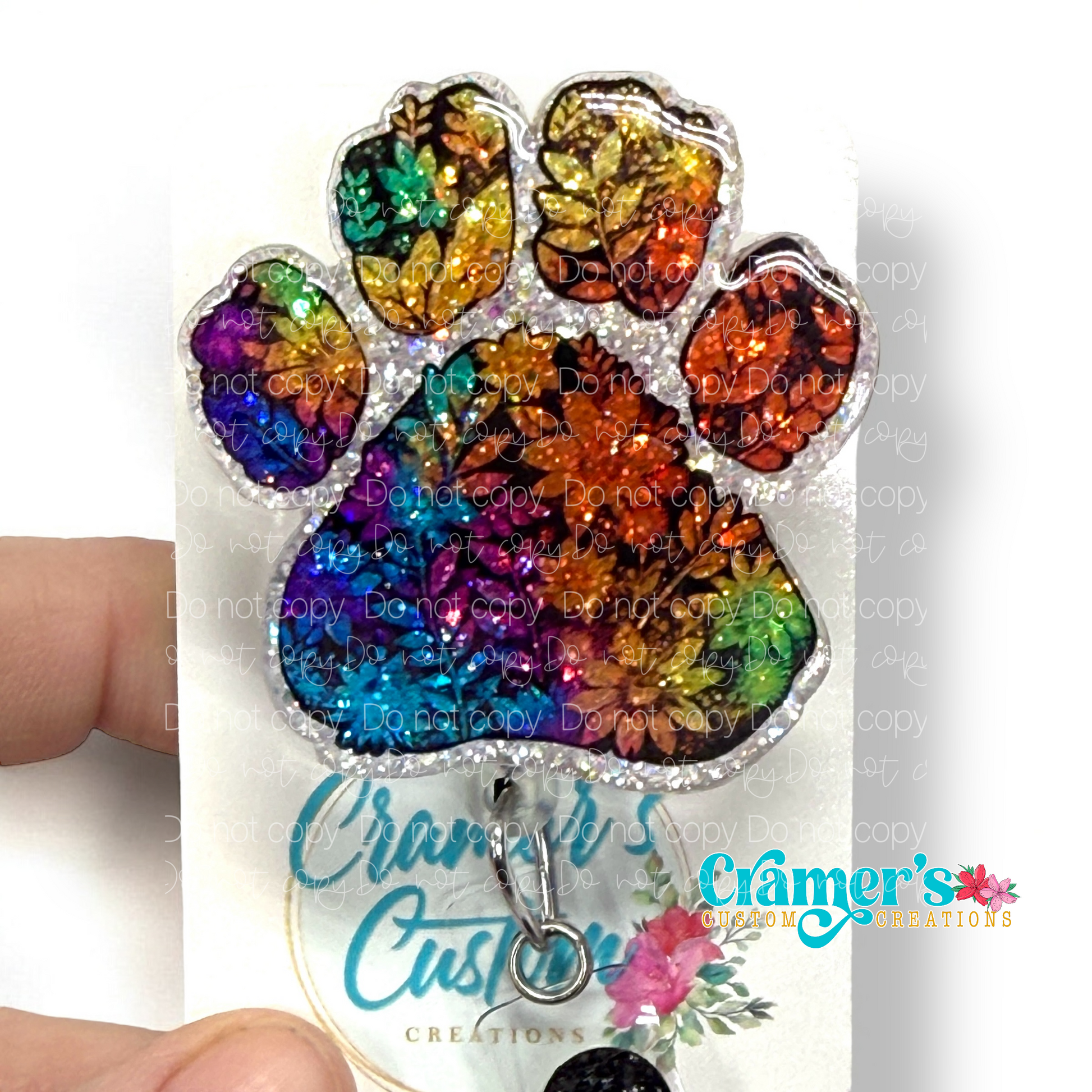 badge reel showing a glitter option of a rainbow colored floral paw print