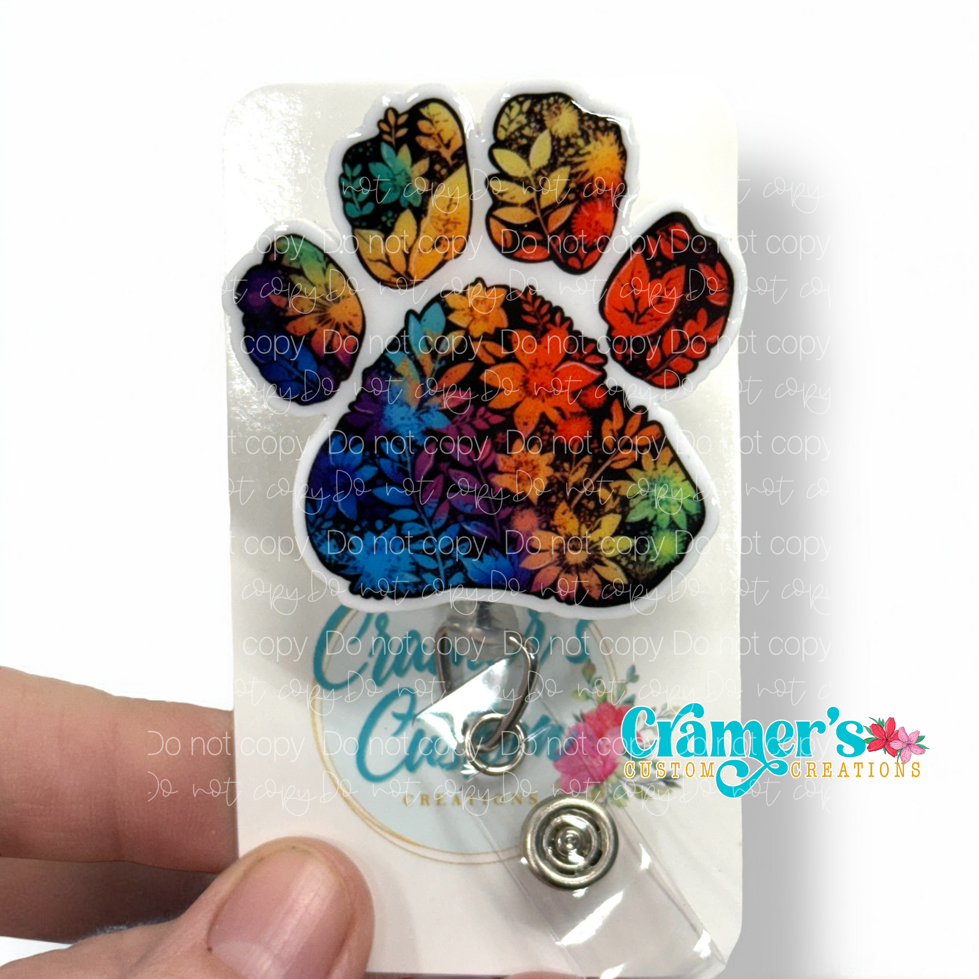 badge reel showing a non glitter option of a rainbow colored floral paw print