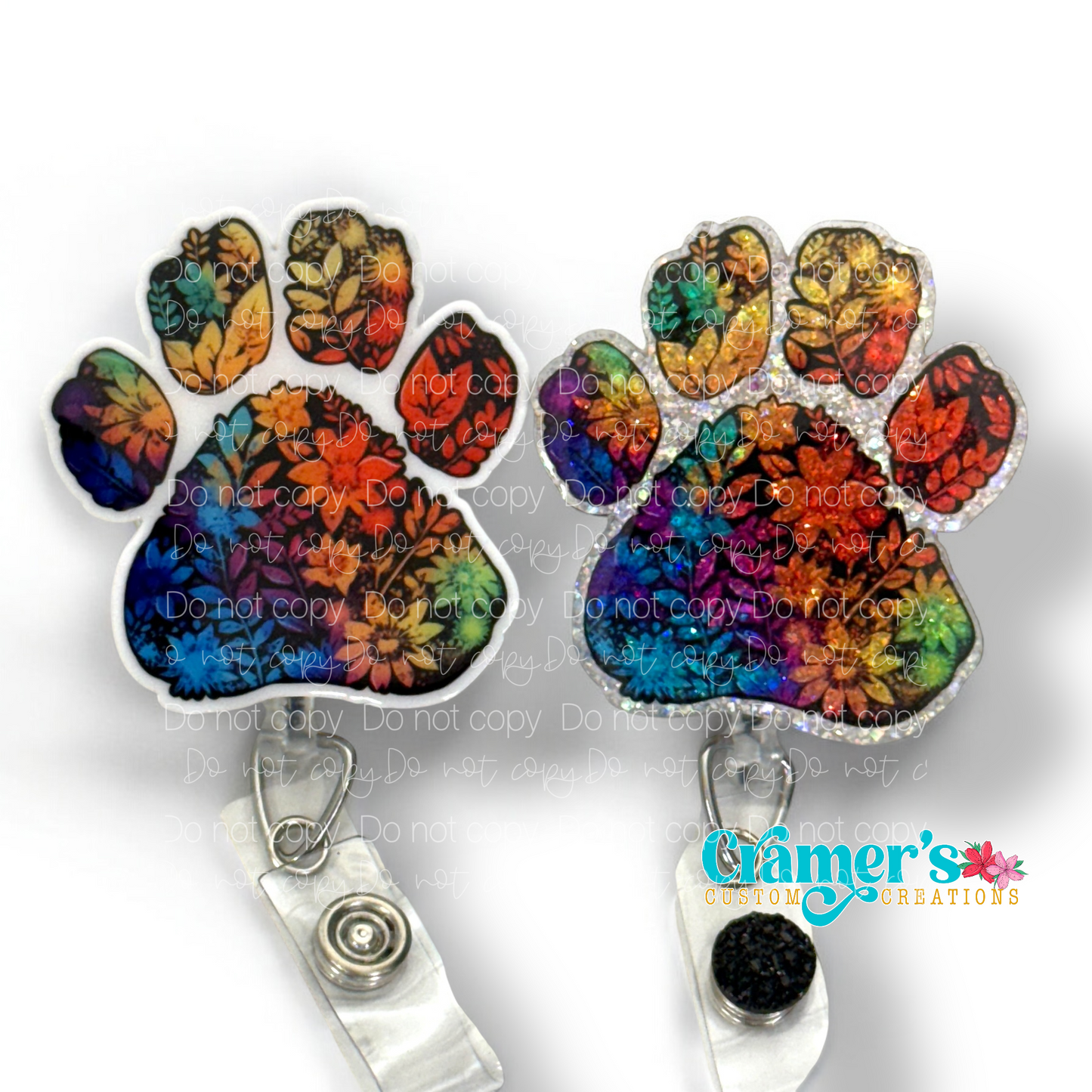 2 badge reels showing a glitter and a non glitter option of a rainbow colored floral paw print